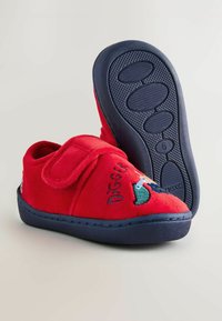 Chaussons rouges pour enfants avec semelles marine, fabriqués en tissu doux. Dotés d'une sangle Velcro et d'un design brodé d'un dinosaure. Semelle texturée pour une meilleure adhérence.