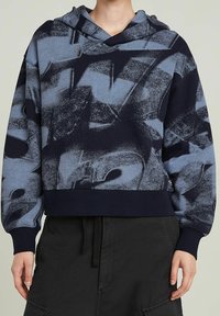 Kapuzensweatshirt in Blau und Navy mit strukturiertem Grafikmuster. Gerippter Saum und Bündchen. Weicher Stoff, entspannte Passform.