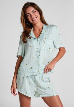 Light blue gingham pajama set featuring short sleeves, a pocket, and small yellow flower patterns, with elasticated shorts for comfort.