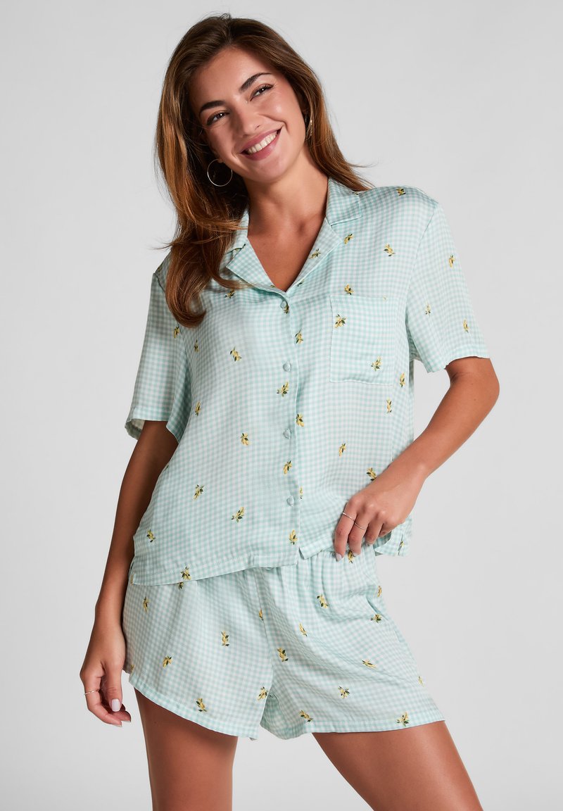 Lichtblauwe gingham pyjama set met korte mouwen, een zak en kleine gele bloemenpatronen, met elastische shorts voor comfort.
