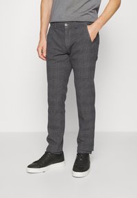 Šedé kostičkované kalhoty vyrobené z lehkého materiálu. Mají slim fit střih, boční kapsy a zapínání na knoflík v pase.