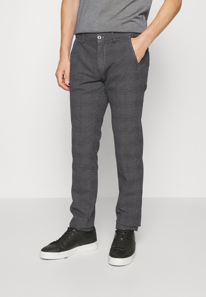 Šedé kostičkované kalhoty vyrobené z lehkého materiálu. Mají slim fit střih, boční kapsy a zapínání na knoflík v pase.