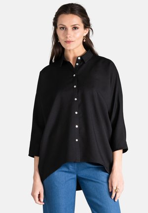 Black button-up shirt with a relaxed fit, featuring a collar, long sleeves, and glossy buttons. Smooth fabric, slightly longer back hem.