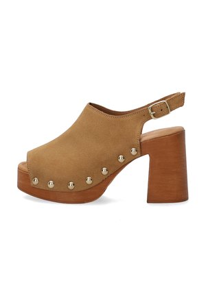 Clogs en daim marron à bout ouvert avec une large sangle et une boucle. Le talon en bois est épais et présente des accents métalliques sur le côté pour des détails.
