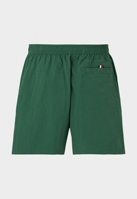 Πράσινα σορτς με ελαστική μέση και πίσω δεξή τσέπη με μικρή λεπτομέρεια κόκκινου, λευκού και μπλε σημαίας.