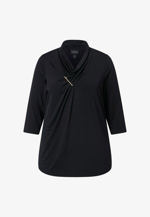 Haut noir à manches longues avec un design à panneau drapé, featuring un accent doré et un col châle. Texture lisse, coupe décontractée.