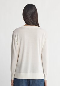 Hellbeige, übergroßer Pullover mit lockerer Passform, gerippten Bündchen und Saum. Weicher Stoff mit einfachem Design, geeignet für legere Kleidung.