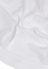 Tessuto in cotone bianco con una consistenza liscia, che mostra pieghe e un orlo cucito. Dettagli minimi con un aspetto semplice e pulito.