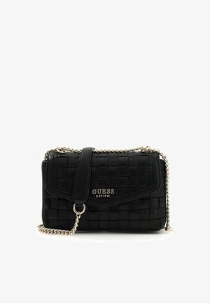 Sac à main matelassé noir de la marque Guess avec une bandoulière en chaîne argentée et une plaque logo sur le rabat avant, posé sur un fond blanc.