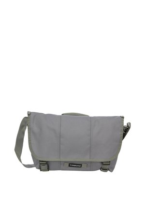Graue Timbuk2 Messenger-Tasche mit verstellbarem Schultergurt und vorderen Schnallenverschlüssen, entworfen zum Tragen persönlicher Gegenstände.