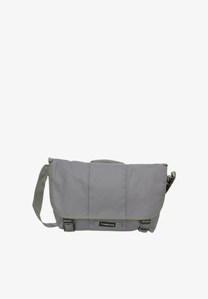 Graue Timbuk2 Messenger-Tasche mit verstellbarem Schultergurt und vorderen Schnallenverschlüssen, entworfen zum Tragen persönlicher Gegenstände.