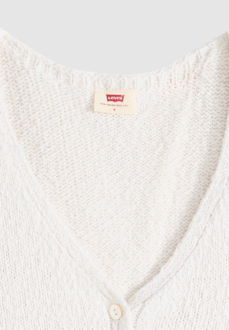 White knitted V-neck cardigan with a single button and a Levi’s brand label showing size small.