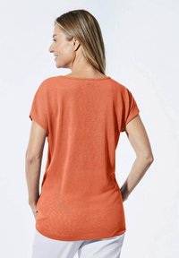 Korte mouwen, relaxed-fit t-shirt in feloranje stof met een gestructureerde uitstraling. Ronde halslijn, langere achterzoom, vlakke naden.