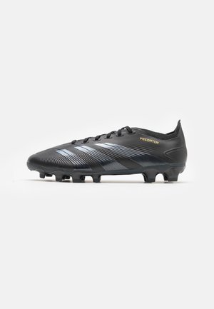 Schwarzer Fußballschuh mit silbernen Streifen, Schnürsenkeln und Nocken, mit dem Wort "PREDATOR" in Gold an der Seite.
