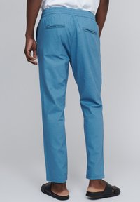 Pantaloni țesuti de culoare albastru deschis, cu talie elastică, două buzunare la spate și un design cu picior drept. Textură netedă, croială lejeră.