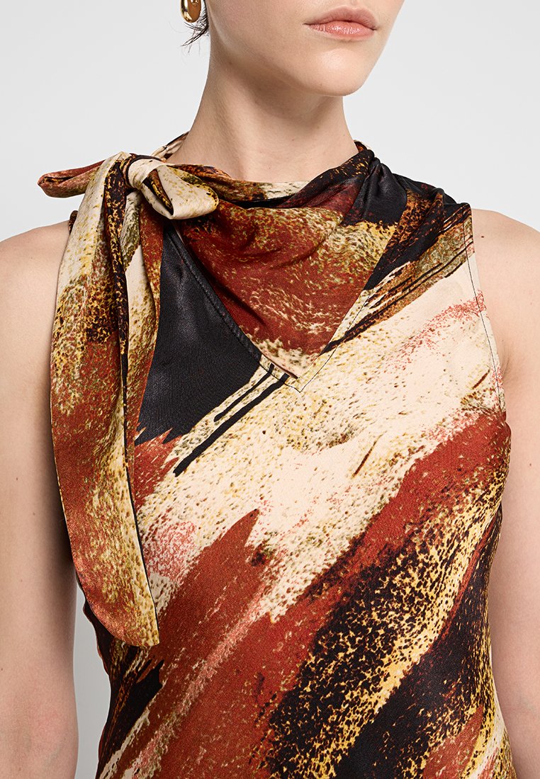 Top sin mangas que presenta una mezcla de tonos tierra, incluyendo marrón, crema y negro, con un patrón abstracto y un detalle de bufanda atada en el hombro.