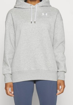 Jasnoszara bluza z kapturem Under Armour z logo na przodzie, kaptur zsuwający się na troczki, długie rękawy, noszona z niebieskimi legginsami.