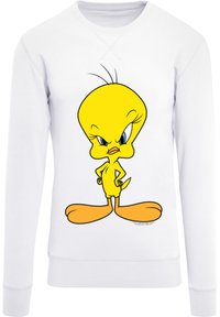 Hvit sweatshirt med et stort, tegneserieaktig gult fuglemotiv med store øyne, en buet hode og store føtter, mot stoffet.