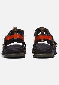 Black and olive green sandals with multiple adjustable straps, featuring an orange accent and a textured sole for grip.