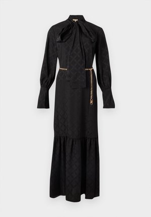 Μαύρο μακρύ φόρεμα με ψηλό γιακά, διακοσμητικό φιόγκο, μακριά μανίκια και στρώσεις στην κάτω όψη. Διαθέτει διακριτικό σχέδιο και ζώνη με χρυσή αλυσίδα.