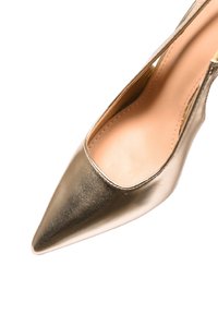 Scarpa con tacco alto a punta in oro metallizzato con superficie texturizzata, lati aperti e interno liscio. Presenta un design elegante.