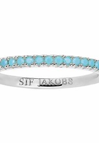 Söljerring prydd med små turkosa stenar, med en slät ringband som har ett ingraverat varumärke. Enkel, smal design.