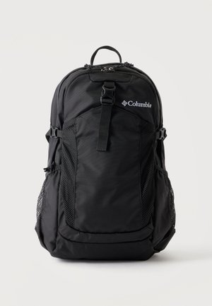 Sac à dos noir Columbia avec sangle à boucle frontale, poches latérales en mesh et poignée de transport supérieure sur fond blanc uni.