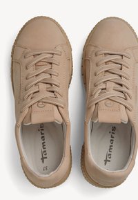 Beige leren sneakers met ronde neus, gewatteerde kraag, veters en een gestructureerde rubberen buitenzool. Aan de binnenkant zijn er een gewatteerde inlegzool en het merkembleem.