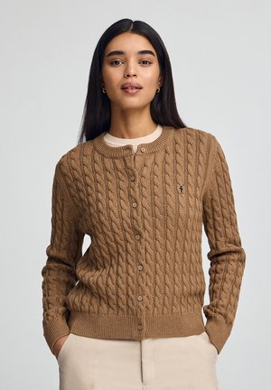 Bruine kabelgebreide cardigan met ronde halslijn, vijf knopen, geribde manchetten en onderrand, met een klein geborduurd logo op de borst.