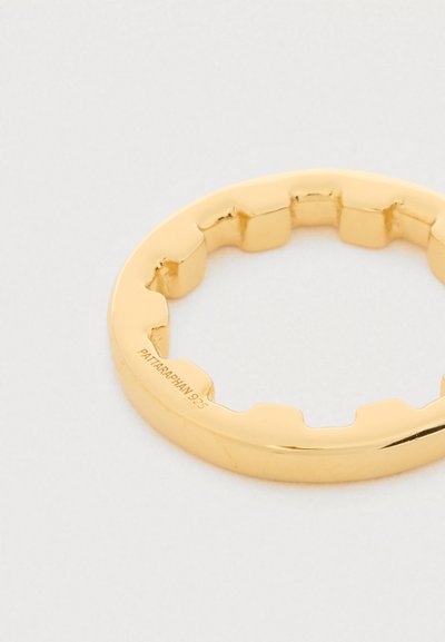 Zlatý prsten s nepravidelným vnitřním okrajem a vnitřním gravírováním "PATTARAPHAN 925", zobrazený na světlém povrchu.