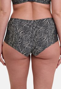 Bas de bikini noir avec un motif floral blanc, doté de détails en dentelle sur les côtés et d'une taille haute pour plus de couverture.