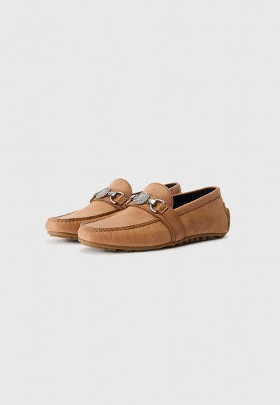 Bruna läderloafers med mockasinsöm och silverfärgade detaljer. Har en låg klack och en strukturerad gummisula för bra grepp.