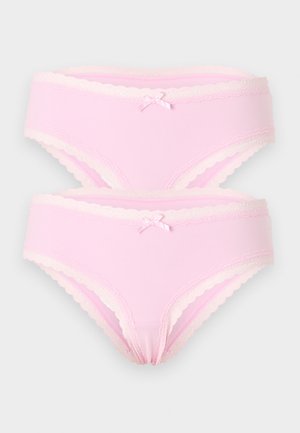 Dva svijetloružičasta ženska pamučna slip gaćica s valovitim čipkama na rubu i malim prednjim mašnicama, složeni na jednobojnoj pozadini.