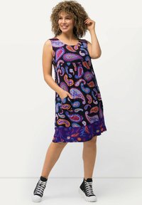 Bezrukávové námořnické šaty s barevným vzorem paisley a bočními kapsami, vyrobené z lehkého materiálu. Mají nařasený pas a zakulacený lem.