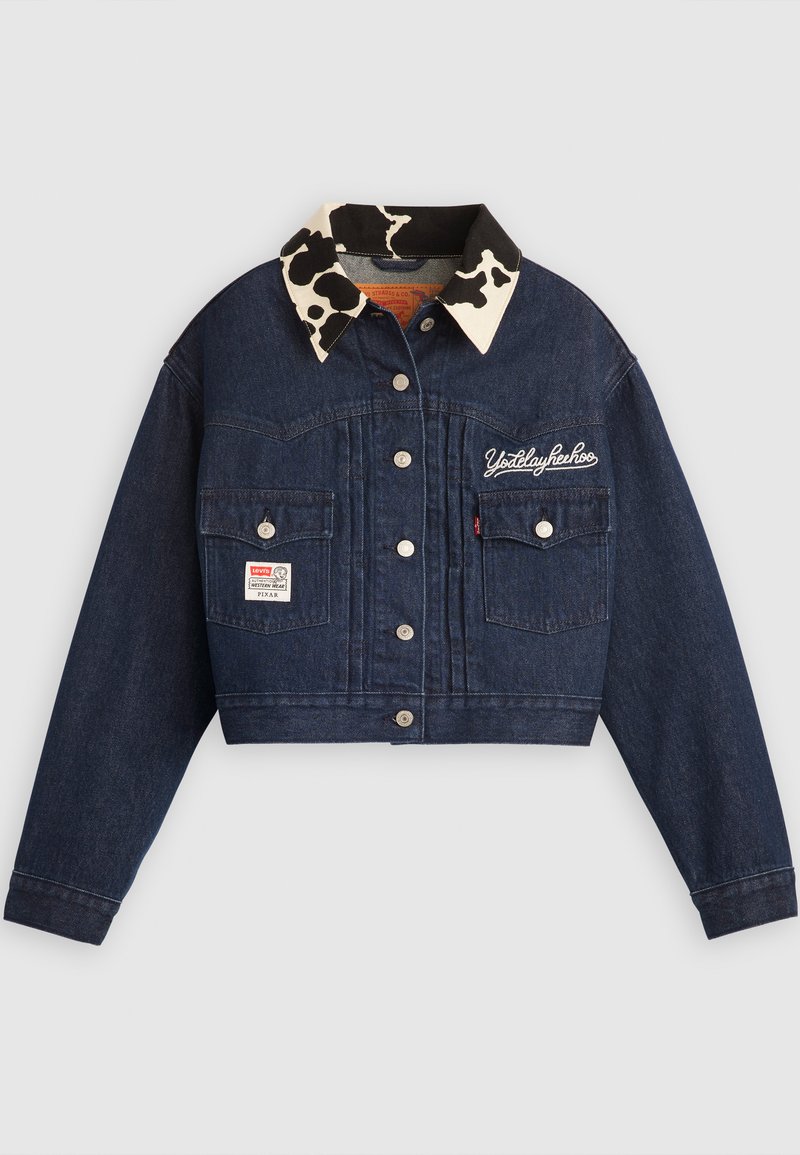Giacca di jeans cropped di colore blu scuro con colletto a stampa mucca, chiusura con bottoni, due tasche sul petto e dettaglio ricamato "Yodelayheehoo".