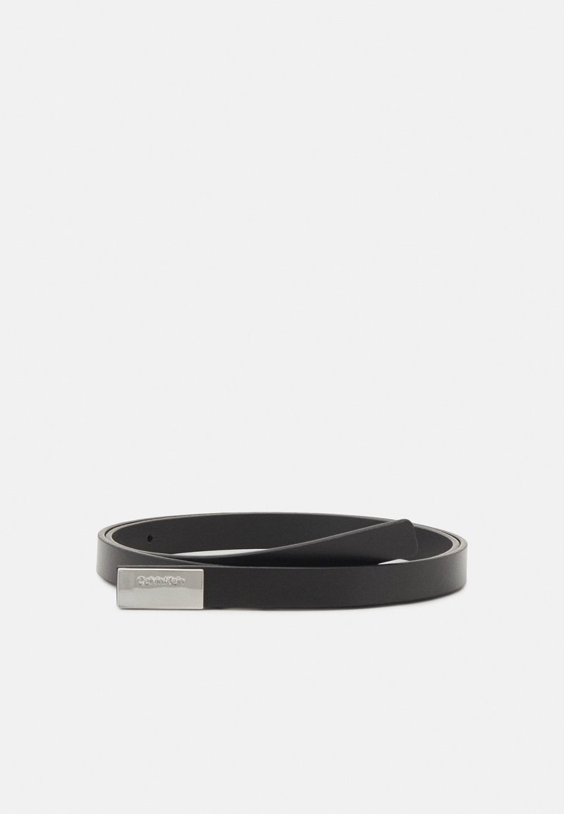 Ceinture en cuir noir enroulée à plat avec une boucle rectangulaire argentée affichant un logo discrètement embossé.
