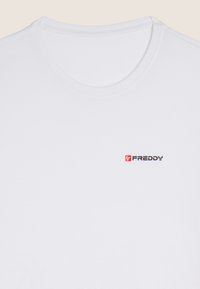T-shirt bianco in cotone con scollo rotondo, caratterizzato da un piccolo logo "FREDDY" rosso e nero sull'area sinistra del petto. Texture liscia.