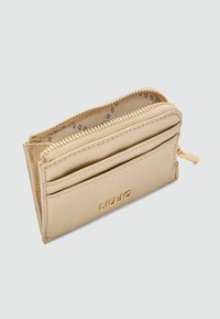 Portafoglio in pelle beige con hardware dorato, dotato di chiusura con zip, più scomparti per carte e rivestimento interno a motivo.