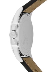 Montre en acier inoxydable argenté avec un bracelet en silicone noir, dotée d'une couronne texturée et d'un fond de boîtier lisse gravé.
