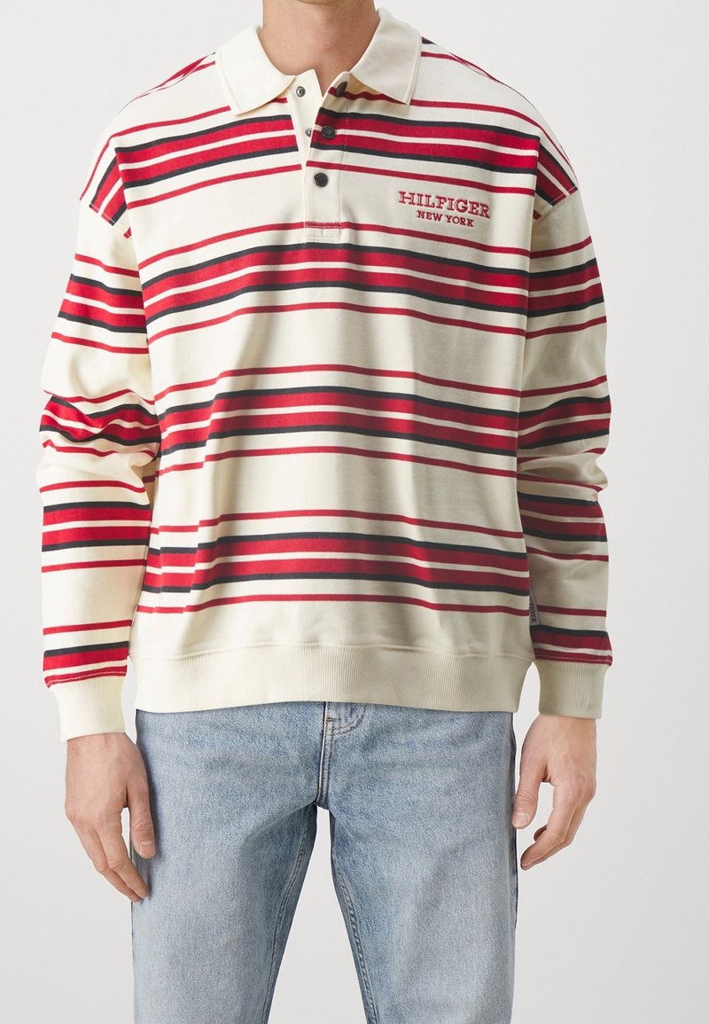 Polohemd in Creme mit roten und schwarzen horizontalen Streifen, mit Kragen, einer Drei-Knopf-Leiste und besticktem Logo auf der Brust.