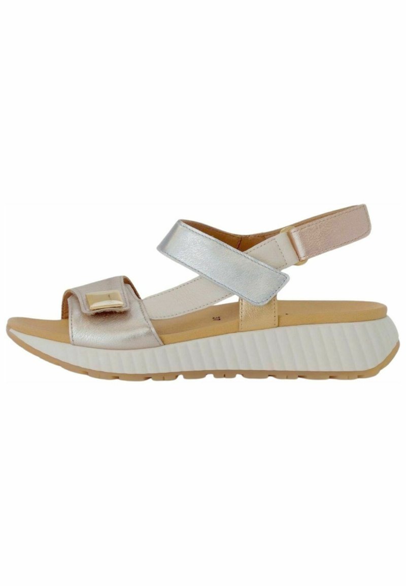 Sandal in argento metallico e beige con una larga fascia e fibbia regolabile, dotato di una suola piatta bianca testurizzata e design con punta aperta.
