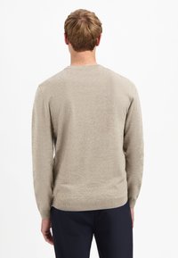 Beige gebreide trui met een ronde hals, lange mouwen en een gestructureerde afwerking. Comfortabele pasvorm met geribde zoom en manchetten.