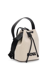 Beige canvas bucket bag med sorte læderdetaljer, snørelukning og justerbar skulderrem. Har præget logo på forsiden.