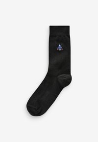Black cotton socks featuring a small, colorful embroidered character on the outer side. Smooth texture and standard sock shape.