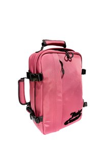 Zaino in nylon rosa con due maniglie laterali, una maniglia superiore, accessori neri e una forma strutturata. Presenta un dettaglio logo testurizzato sul davanti.