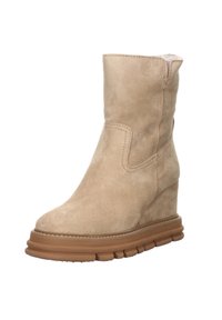 Bottine en daim beige avec semelle compensée et bout rond, dotée d'une semelle extérieure en caoutchouc marron striée et superposée pour une meilleure traction.