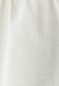 Kergedest valmistatud kangas helesinises beežis värvitoonis, millel on peene tekstuuriga kudumine, näidates peeneid variatsioone ja pehmet väljanägemist.