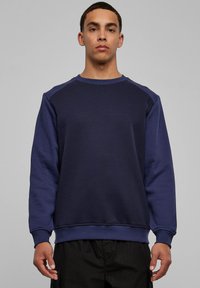 Meresinine pusa  ümara kaelusega, raglaanvarrukate ja soonikkoes varrukaservadega. Valmistatud pehmest kangast, millel on siledapintseline tekstuur. Lihtne disain.