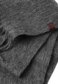 Grijze vilten deken met een zachte textuur, met een rechthoekige vorm en een klein bruin leren label in één hoek.