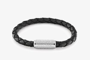 Zwarte leren gevlochten armband met een zilverkleurige metalen sluiting met gegraveerd patroon en "HILFIGER" branding.